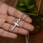 Cross necklace for daughter held in hand