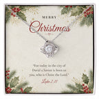 Christian Christmas Love Knot necklace laid on "Merry Christmas" Luke 2:11 message card