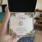 Hand holding open gift box with silver finish Love Knot necklace for Mom from Son and classic message card