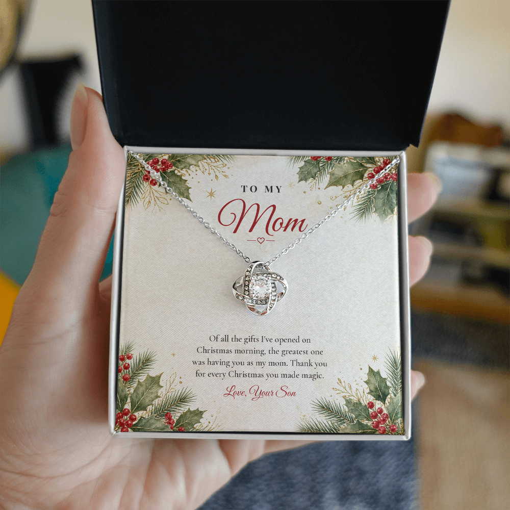 Hand holding open gift box with silver finish Love Knot necklace for Mom from Son and classic message card