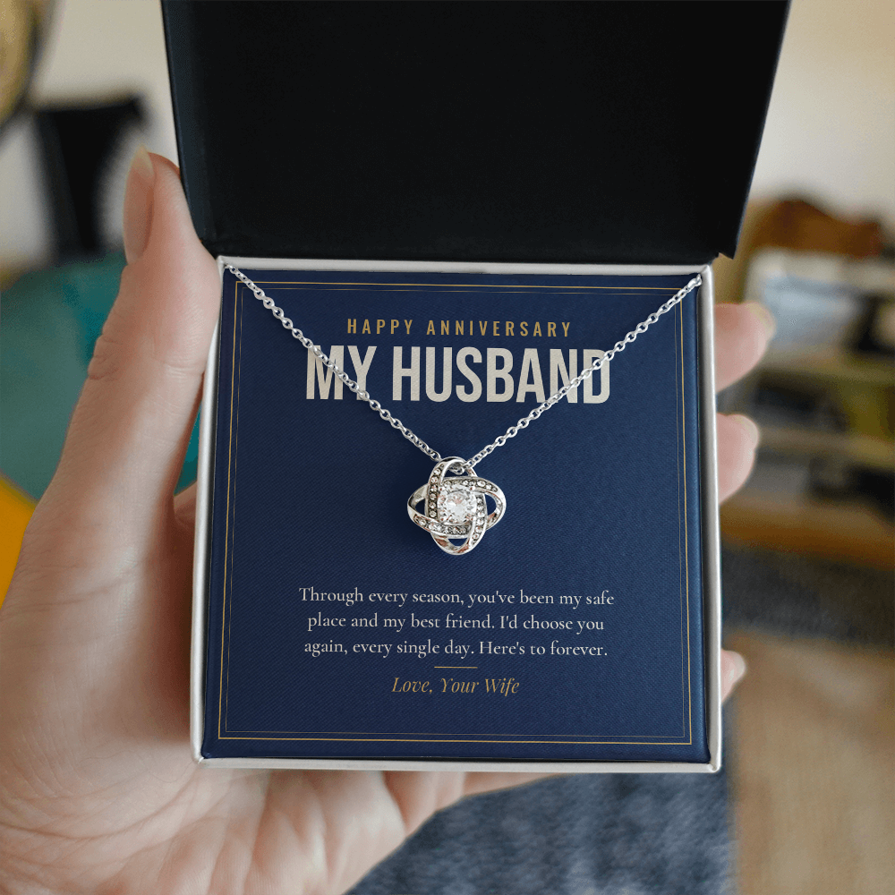 Hand holding open gift box with 14K white gold finish Anniversary Love Knot necklace for Husband and "Happy Anniversary My Husband" message card