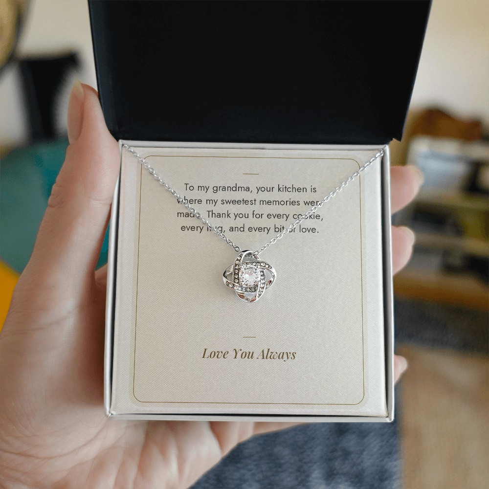 Hand holding gift box with white gold Love Knot necklace for Grandma and Sweetest Memories message card