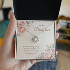 Hand holding open gift box with silver finish Christian Love Knot necklace for Daughter and Philippians 4:13 message card