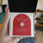 Hand holding open gift box with silver finish Love Knot necklace for Mom from Daughter and modern message card