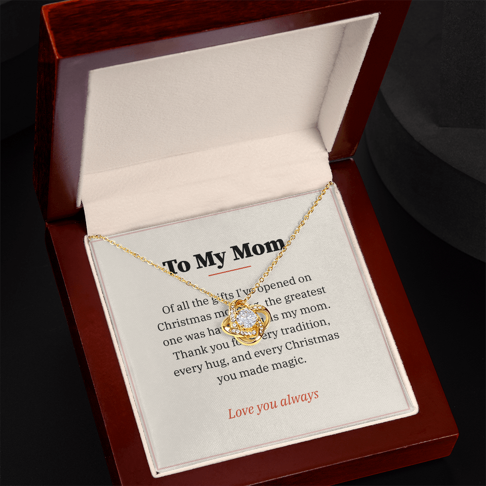 Yellow gold Love Knot necklace and To My Mom message card in open mahogany luxury box on dark background