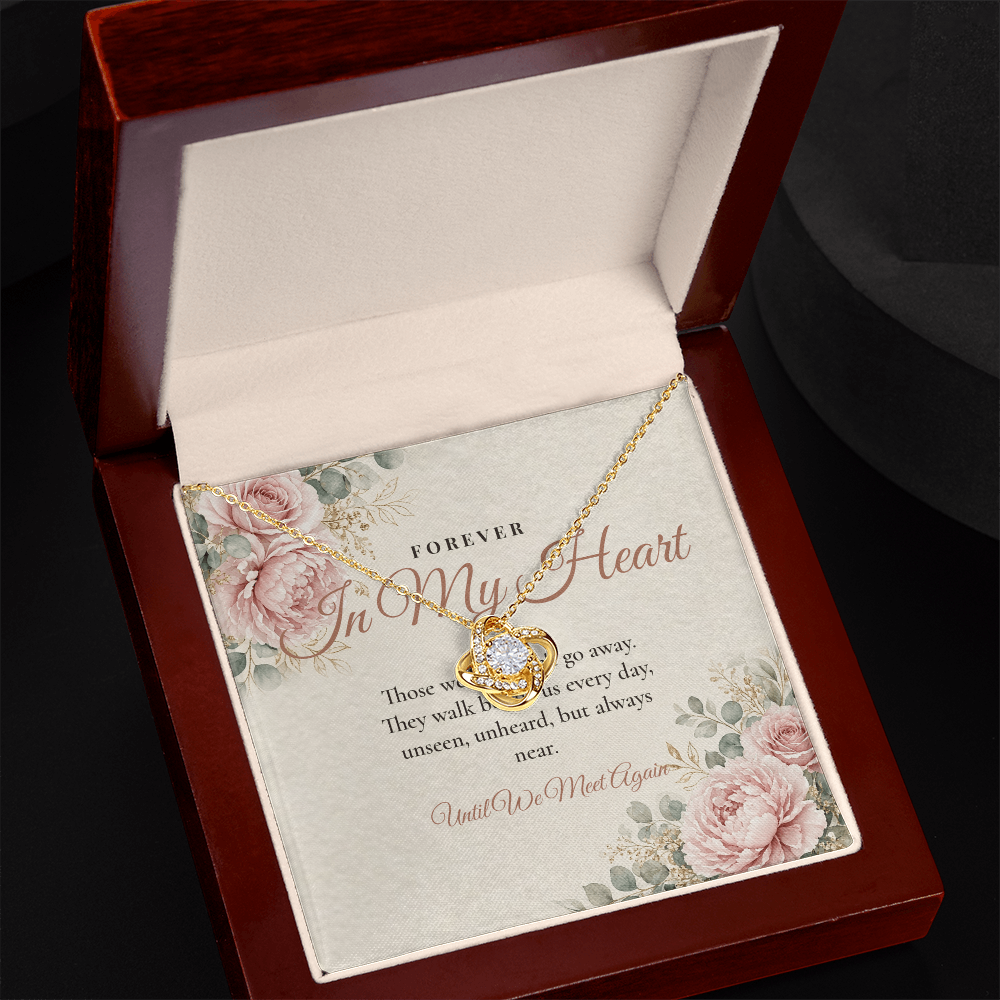Yellow gold memorial Love Knot necklace and Forever In My Heart message card in open mahogany luxury box on dark background