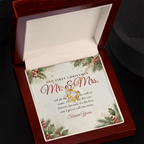 Yellow gold Love Knot necklace for wife and Our First Christmas Mr. & Mrs. message card in open mahogany luxury box on dark background