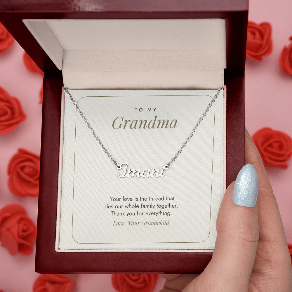 Grandma name necklace in mahogany gift box held in hand over red roses, minimalist white message card – name necklace for Grandma