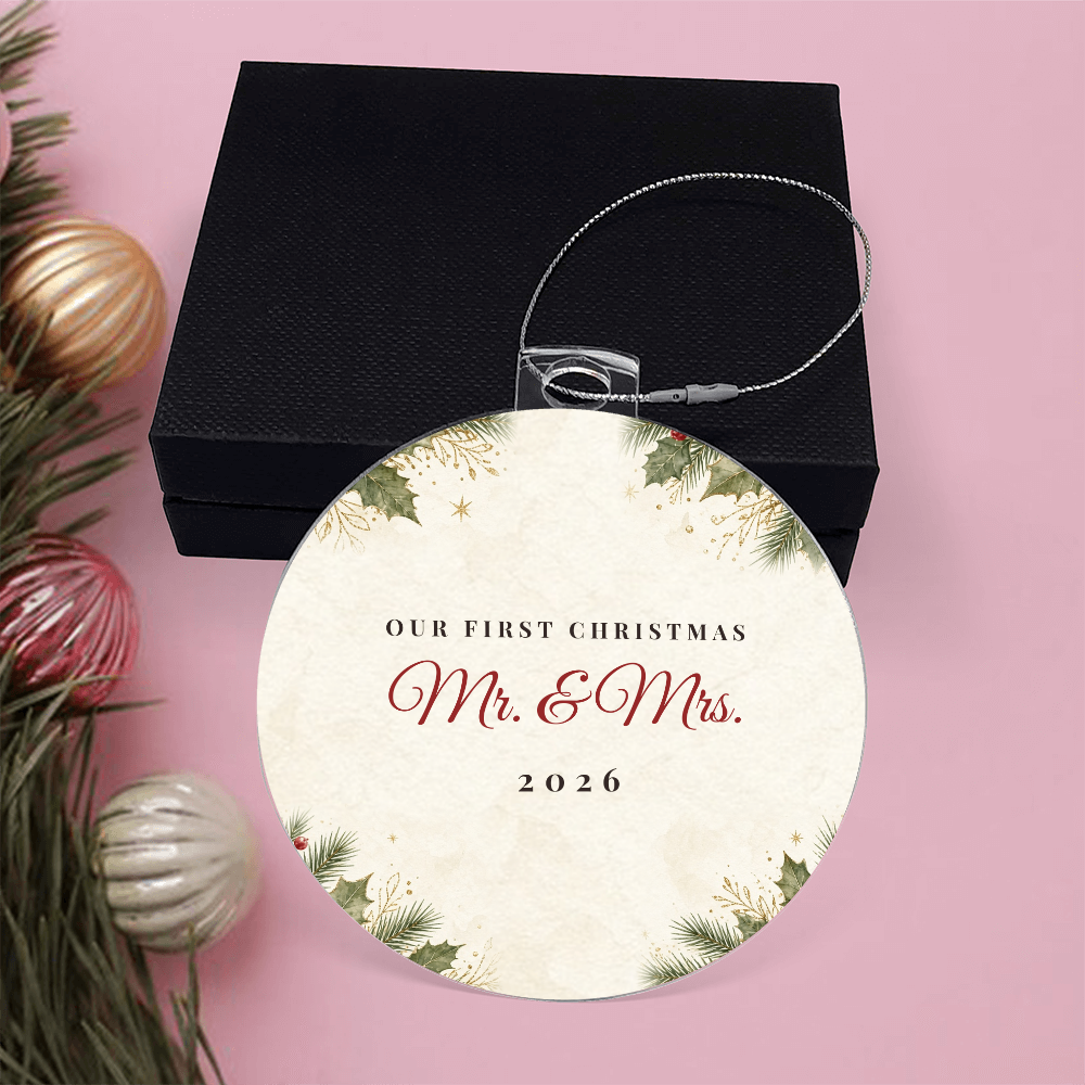 Acrylic bulb ornament with Our First Christmas Mr. & Mrs. 2026 design with black gift box on pink background