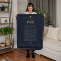 Woman holding a navy blue prayer blanket for dad with printed prayer in a living room