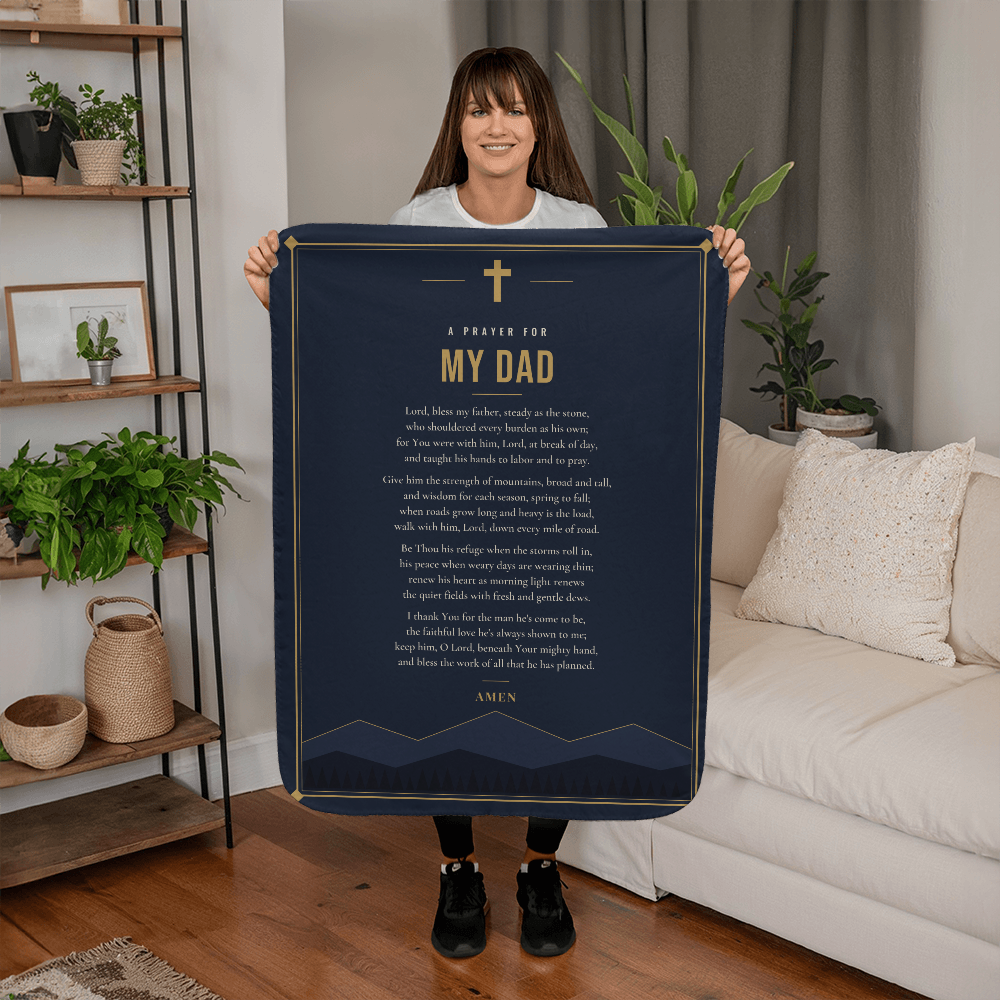 Woman holding a navy blue prayer blanket for dad with printed prayer in a living room