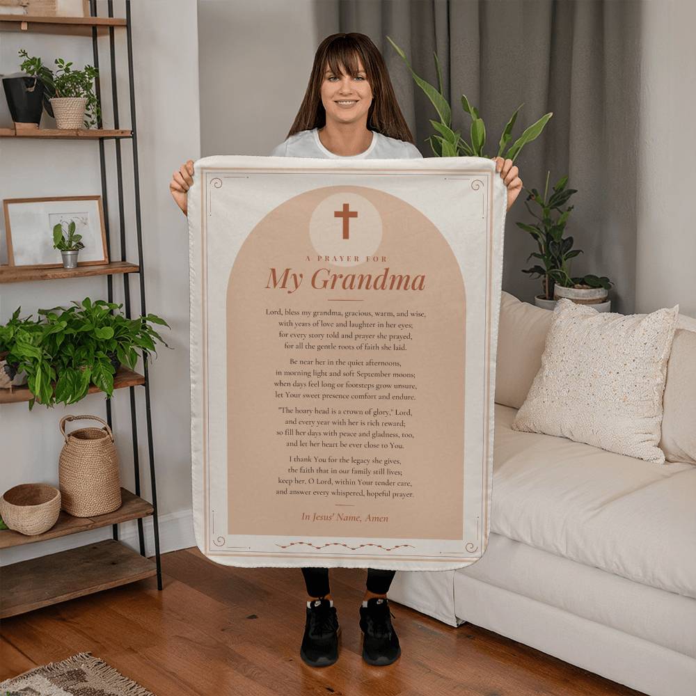 Woman holding a peach prayer blanket for grandma with printed prayer in a living room