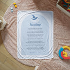 Light blue healing prayer blanket with printed prayer spread on a cozy rug