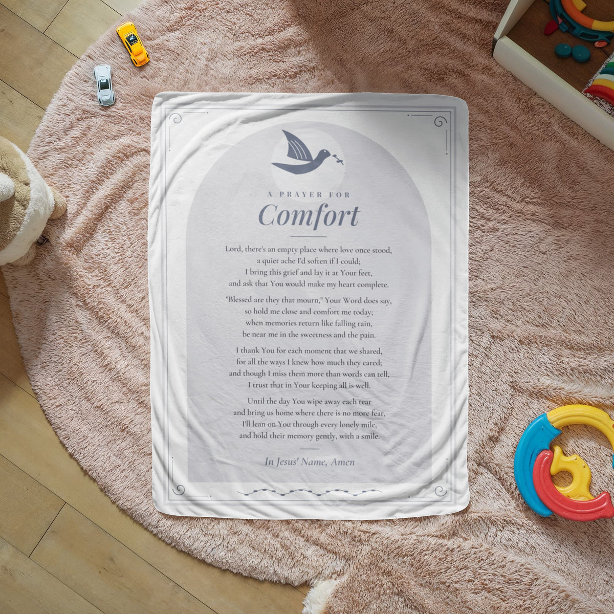 Gray comfort prayer blanket with printed prayer spread on a cozy rug